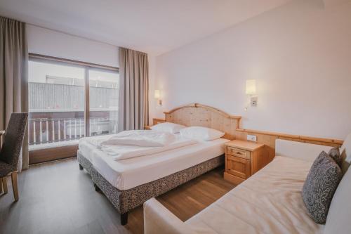 a hotel room with two beds and a window at Hotel Innerhofer in Gais