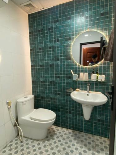 a bathroom with a toilet and a sink and a mirror at Little House Đông Tác in Hanoi