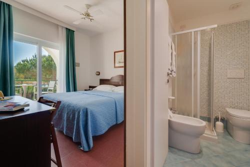 a bedroom with a bed and a tub and a toilet at Hotel Antares in Capoliveri
