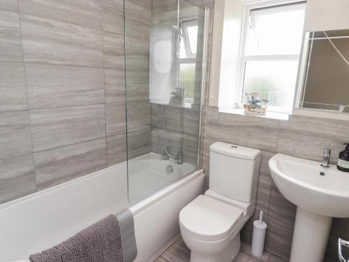 a bathroom with a toilet and a tub and a sink at 7 Cwrt Y Cadno in Llantwit Major