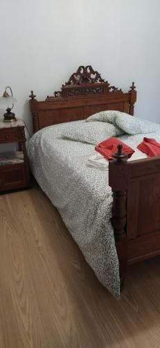 a bedroom with a bed with a wooden head board at Casa da Corredoura in Penafiel