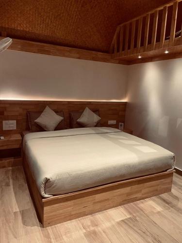 a bedroom with a large bed with a wooden headboard at Wanderlust Beach Villa in Agatti