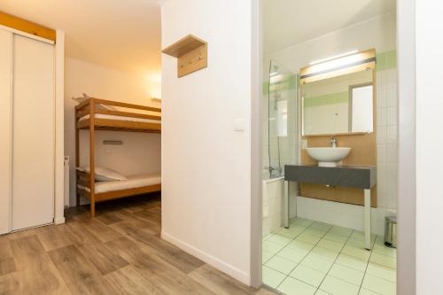 a bathroom with a sink and a mirror and a bunk bed at Résidence Odalys Le Pelvoux in La Plagne