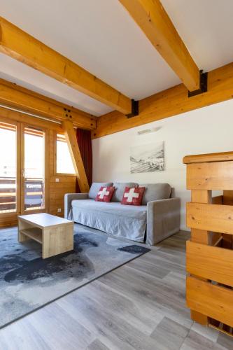 a living room with a couch and a table at Résidence Odalys Le Pelvoux in La Plagne