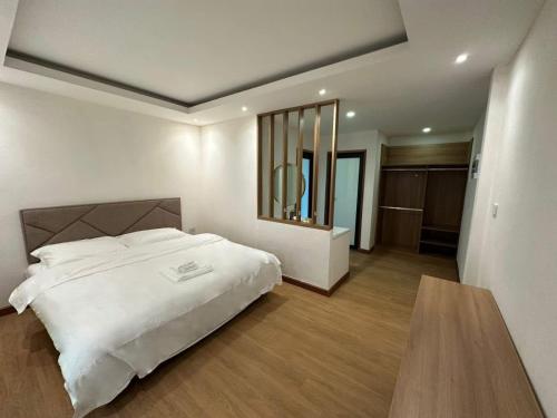 a bedroom with a large white bed and a table at Openview Resort Thakhek in Thakhek