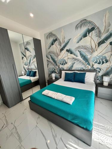 a bedroom with a blue bed with a mural at Silviaapartment in Battipaglia