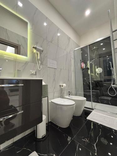 a bathroom with a toilet and a sink and a shower at Silviaapartment in Battipaglia
