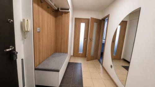 a hallway with a bench and a mirror at Bytča Central Apartment in Bytca