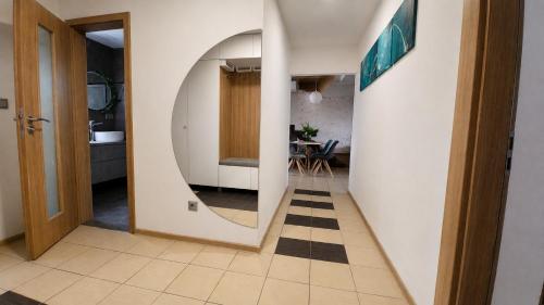 a hallway with a mirror and a room with a table at Bytča Central Apartment in Bytca