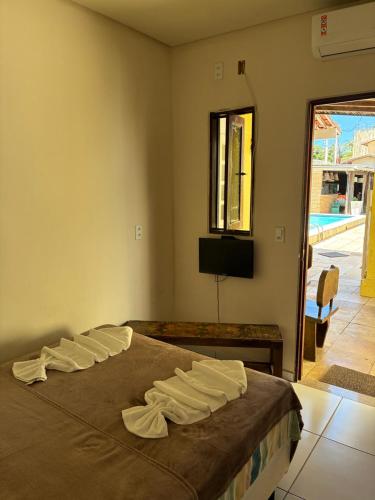a bedroom with a bed with white towels on it at Pousada Sapê in Praia do Frances