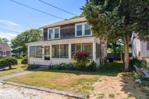 a white house with windows and a tree at Steps to the Beach Cozy Central AC in Yarmouth