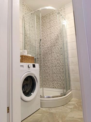 a washing machine in a bathroom with a shower at Apartman Mali Tare in Korčula