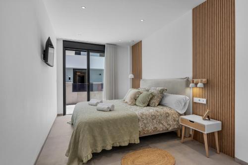 a bedroom with a bed and a large window at Casa Maku in San Pedro del Pinatar