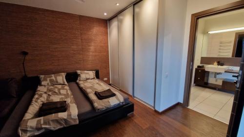 a bedroom with a bed and a bathroom at Modern skyline-view condo at a luxury complex in Vilnius