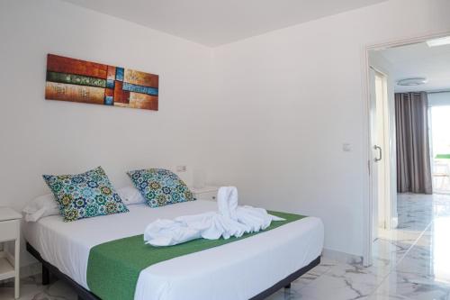 a bedroom with a white bed with towels on it at Rayito de sol 3 in Costa de Antigua