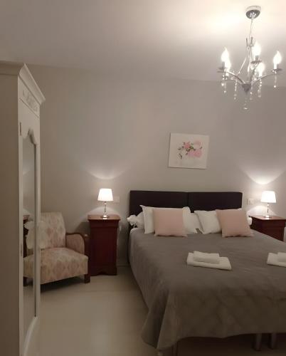 a bedroom with a bed and a chair and a chandelier at Entre Brionnais Et Bourbonnais in Montaigüet-en-Forez