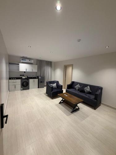 a living room with a black couch and a table at شقق درة القويعية in Al Quway‘īyah