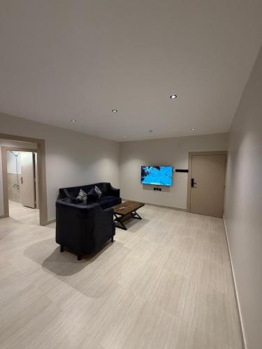 a large living room with a couch and a flat screen tv at شقق درة القويعية in Al Quway‘īyah