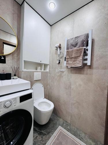 a bathroom with a toilet and a washing machine at Квартира in Temirtaū