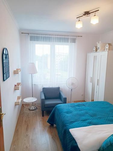a bedroom with a blue bed and a blue chair at Royal Nest Apartment Sandomierz in Sandomierz