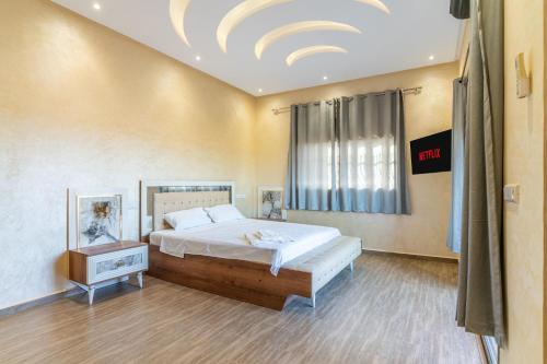 a bedroom with a large bed and a window at Petit-villa avec piscine in Marrakesh