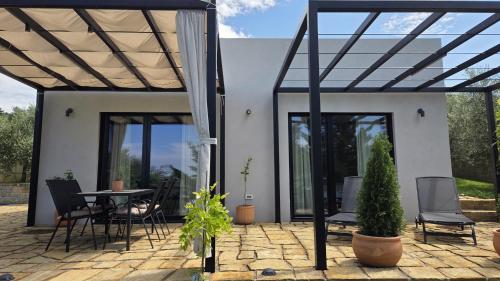 a house with a patio with a table and chairs at House B in Dekani