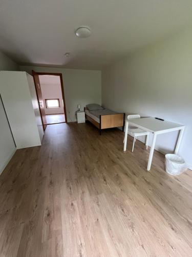an empty room with a table and a bed at Einzelzimmer in Jerrishoe