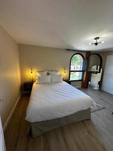 a bedroom with a bed with white sheets and pillows at Suite Rivière in Lèves