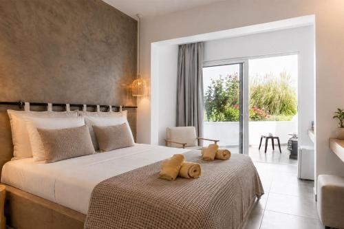 a bedroom with a bed with two teddy bears on it at RHODEA Mar in Faliraki