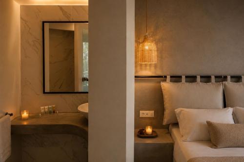 a bathroom with a bed and a sink and a mirror at RHODEA Mar in Faliraki