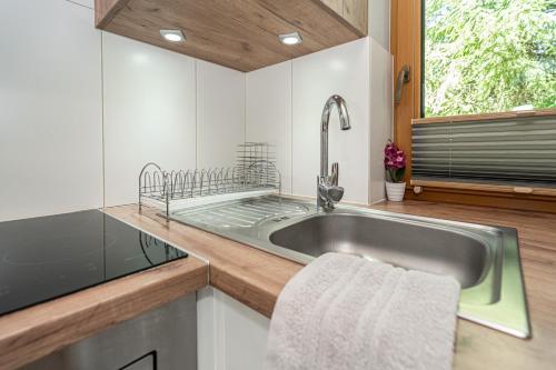 a kitchen with a stainless steel sink and a window at Kirowy Domek I in Kościelisko