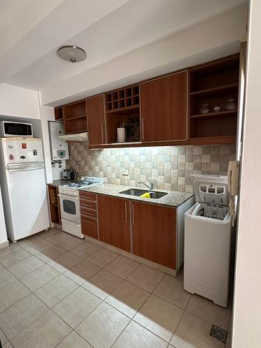 a kitchen with wooden cabinets and white appliances at Descanso Sereno in Junín