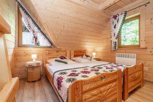 a bedroom with a bed in a log cabin at Kirowy Domek I in Kościelisko