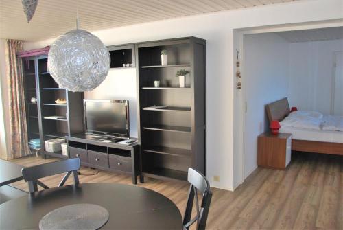 a living room with a dining table and a television at Haus Nautic Whg 810 Seesicht in Cuxhaven
