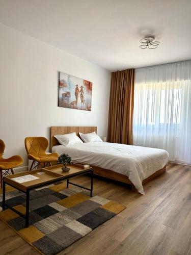 a bedroom with a large bed and a coffee table at Contemporary Studio with Balcony - New Building in Bucharest