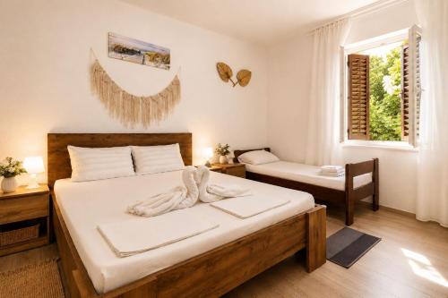 a bedroom with a bed and a chair and a window at Apartmani Bonaca in Pakoštane