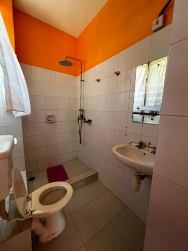 a bathroom with a toilet and a sink at PRIMESHADE GUESTHOUSE in Malindi