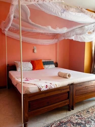 a bedroom with a bunk bed with a canopy at PRIMESHADE GUESTHOUSE in Malindi