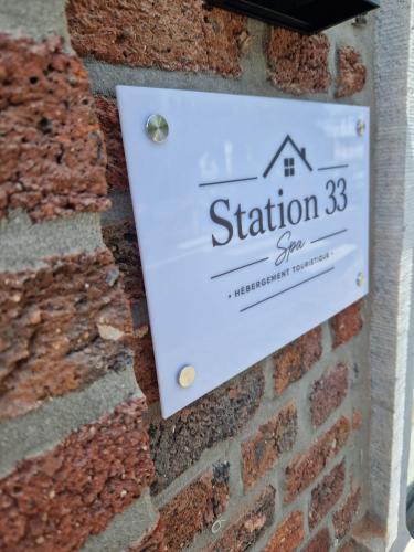 a sign for the station sign on a brick wall at Station 33 in Spa