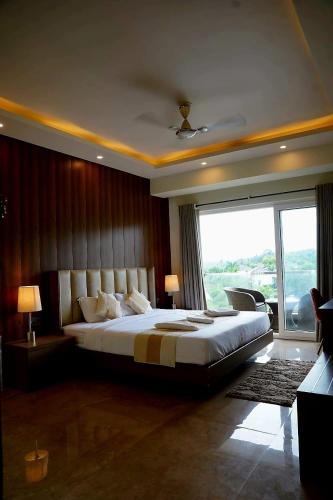 a bedroom with a large bed and a large window at SOLARAA iNN in Anjuna
