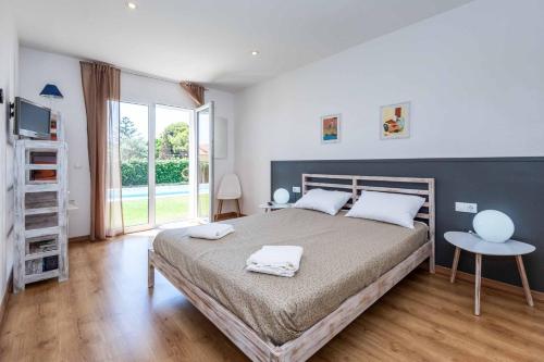 a bedroom with a large bed with two towels on it at Villa Sol de Flandes in Punta Prima