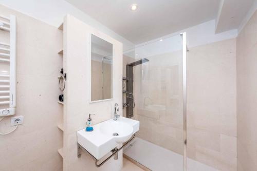 a white bathroom with a sink and a shower at Villa Sol de Flandes in Punta Prima