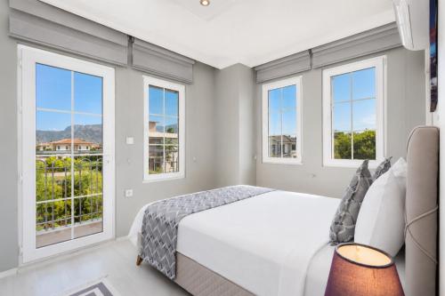 a bedroom with windows and a bed and a couch at Villa Delfin in Ortaca
