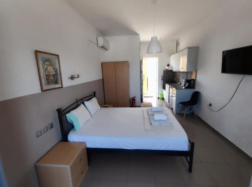 a bedroom with a white bed and a box at Seaview Studio in Gázion