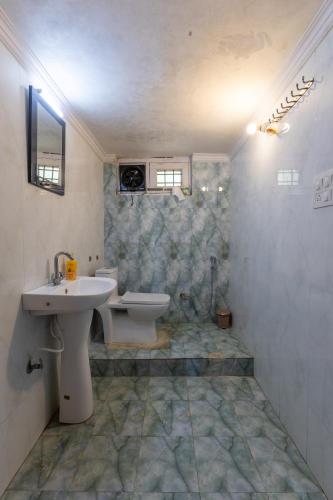 a bathroom with a sink and a toilet at Vrishti Homestay in Bhīm Tāl