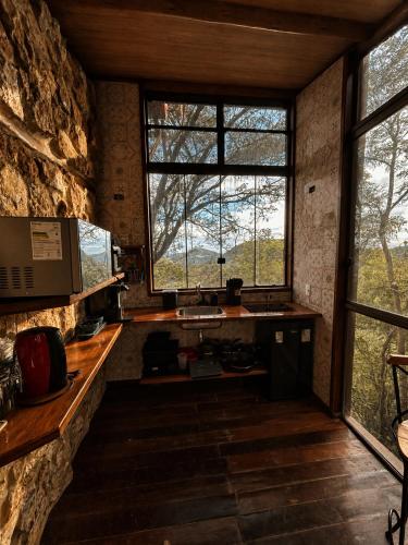 a kitchen with a sink and a window in a room at Chalé da Árvore - Refúgio das Videiras in Moeda