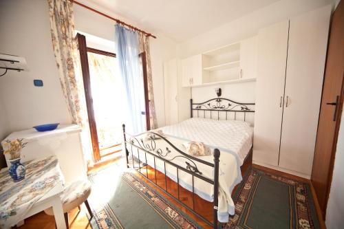 a bedroom with a bed and a window at Apartments Vila Miranda in Barbat na Rabu