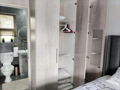a small bathroom with a toilet and a sink at The Room Above in Brackenfell
