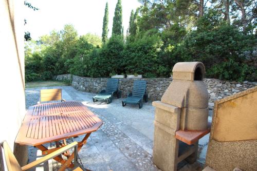 a patio with chairs and a table and a stone wall at Makarska city center1 willa in Makarska