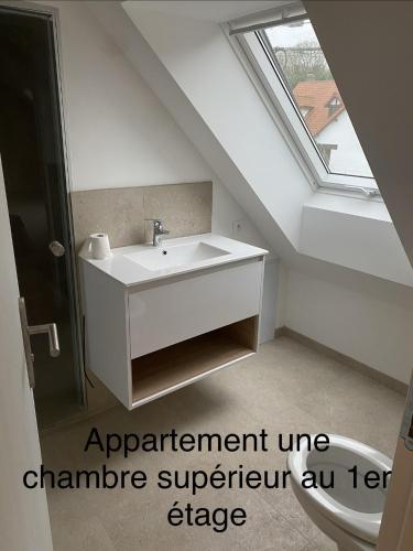 an attic bathroom with a sink and a window at Gîte du Flot - Baie de Somme in Boismont